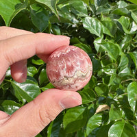 Close-up of a polished Rhodochrosite Sphere with smooth surface