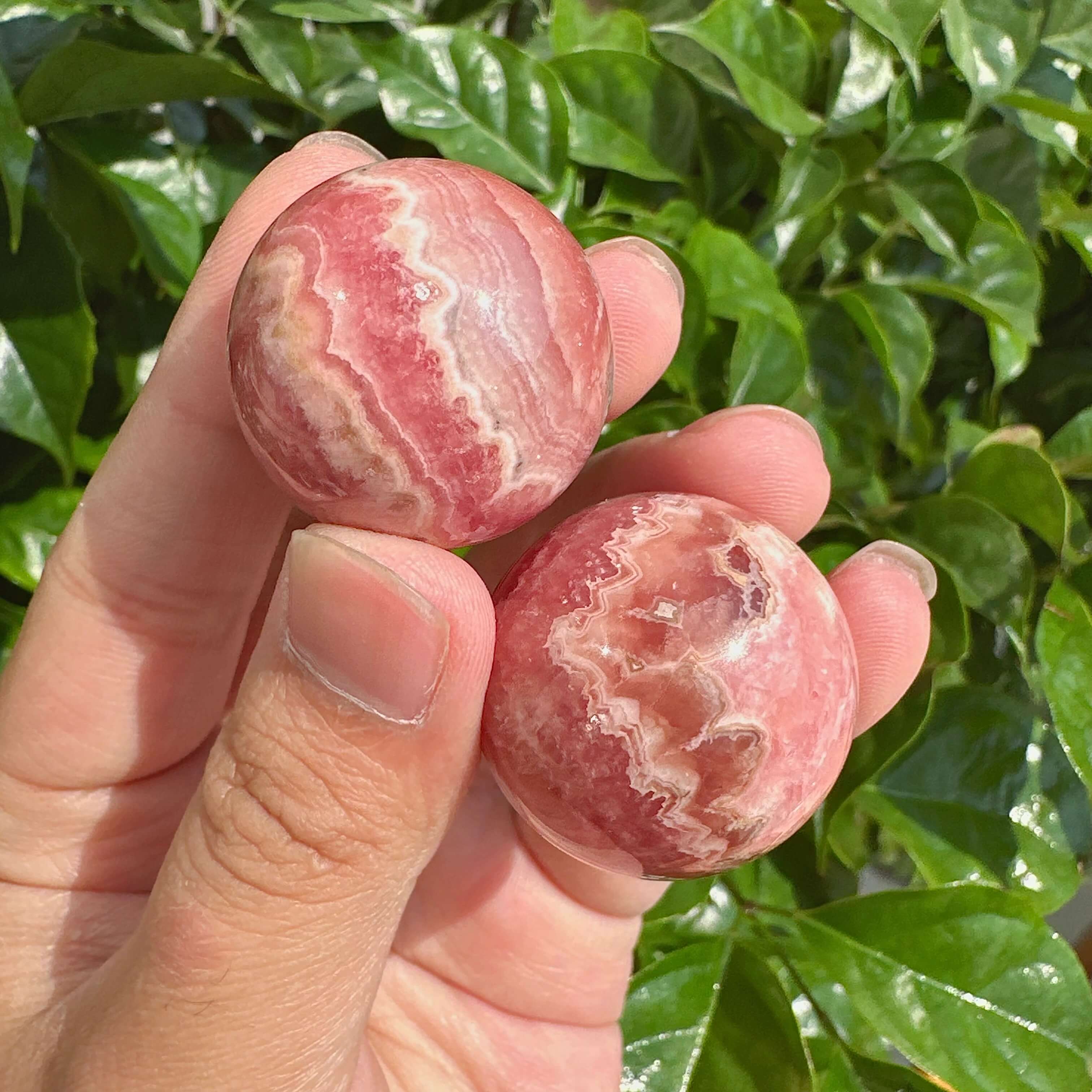 Rhodochrosite Sphere with vibrant pink hues and white accents