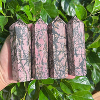 Close-up view of a Rhodonite Tower, highlighting its unique pink and black color contrast and natural texture.