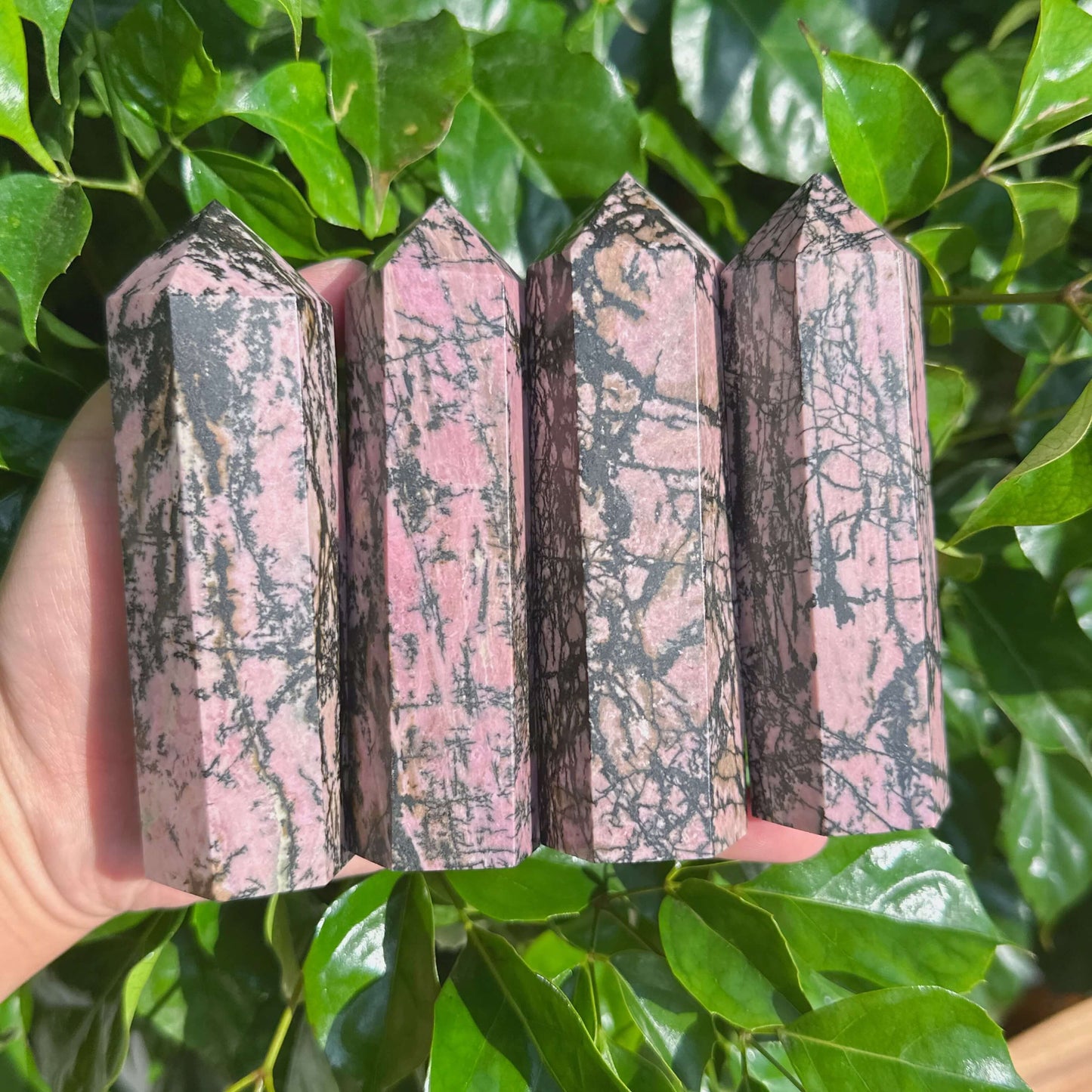 Close-up view of a Rhodonite Tower, highlighting its unique pink and black color contrast and natural texture.