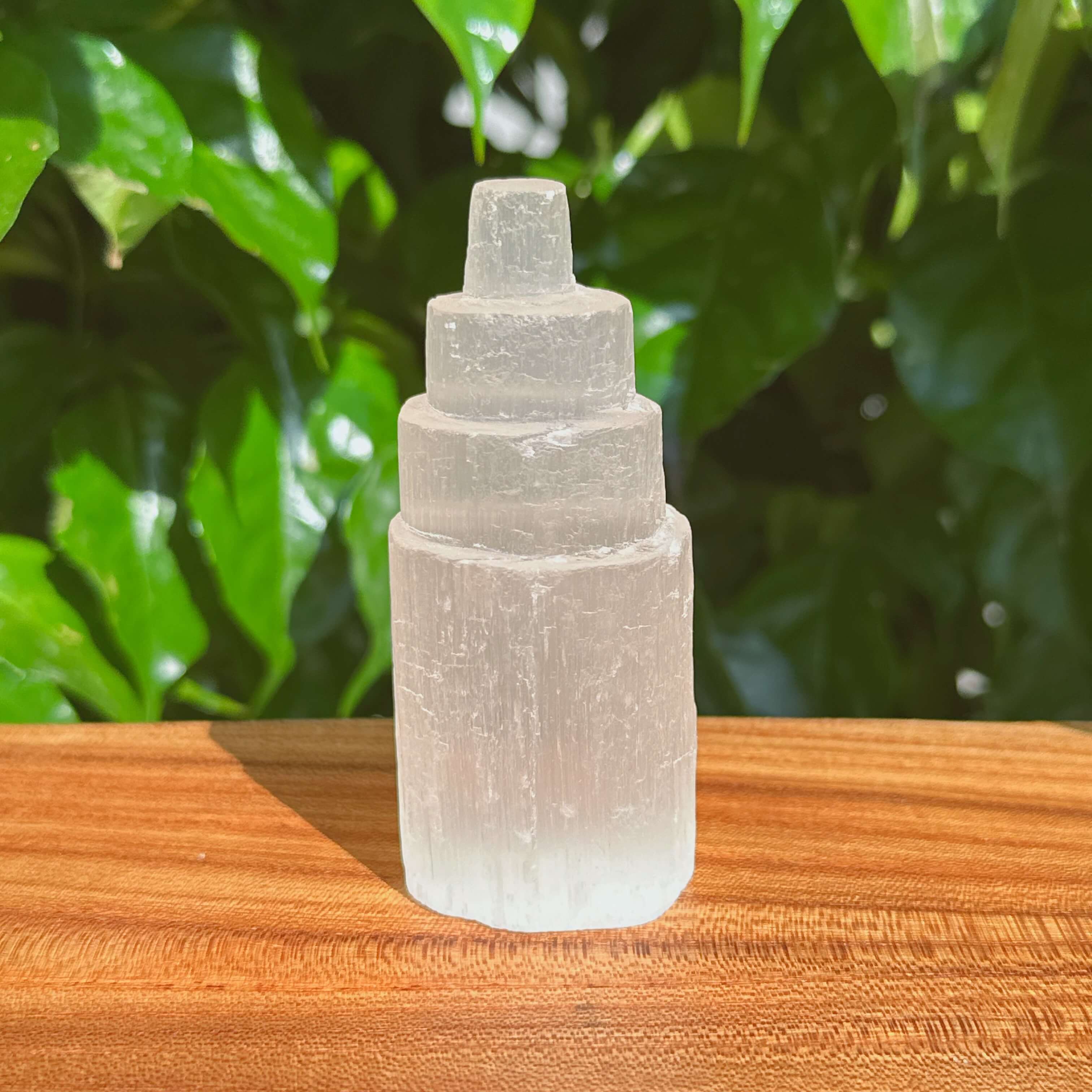 Selenite Tower held in hand, emphasizing its compact size and beautiful crystal structure, ideal for energy healing and meditation.
