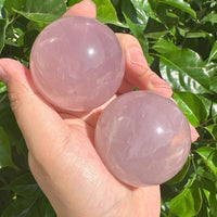Close-up of the Star Rose Quartz Sphere, highlighting its translucent pink hues and the gentle star-shaped reflection at its center.