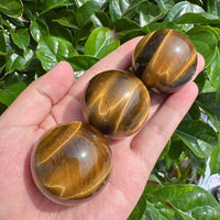 Tiger Eye sphere with strong golden light reflections, ideal for decor.