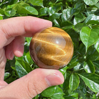 Natural Tiger Eye sphere with smooth polished surface for energy healing.