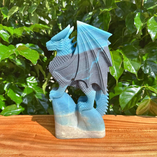 Trolleite Dragon Carving held in hand, offering a clear perspective of the sculptural details and the unique combination of blue and grey tones in the dragon's form.