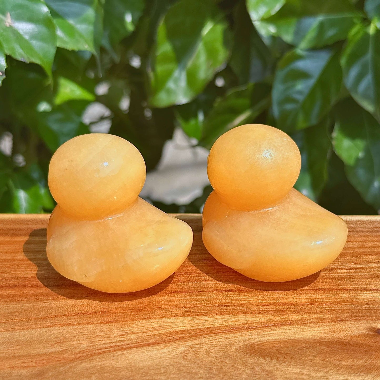 Yellow Calcite Duck Carving held by hand with a clear background, emphasizing the fine detailing.